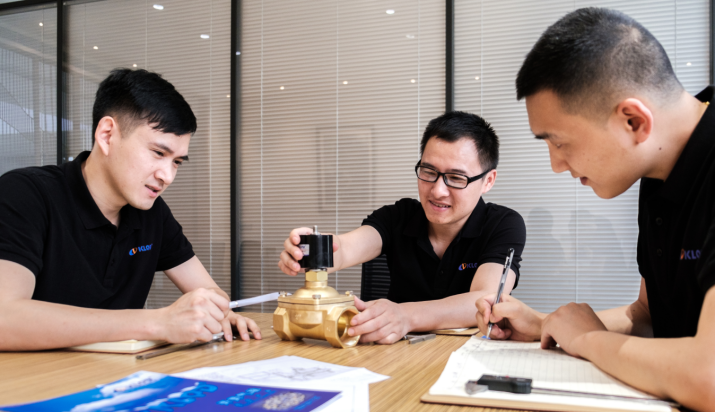 Kailing engineers reviewing a pneumatic valve and technical drawing
